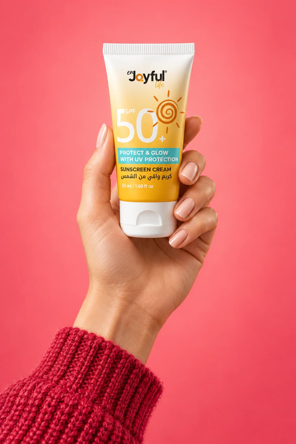 Enjoyful Life SPF 50+ sunscreen held against a coral background